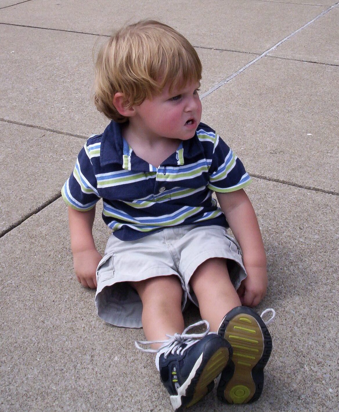 2006318 A toddler sitting on the ground throwing a tantrum.